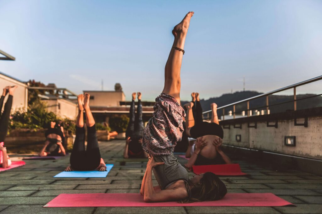 plusieurs femmes faisant du yoga sur une terrasse dehors